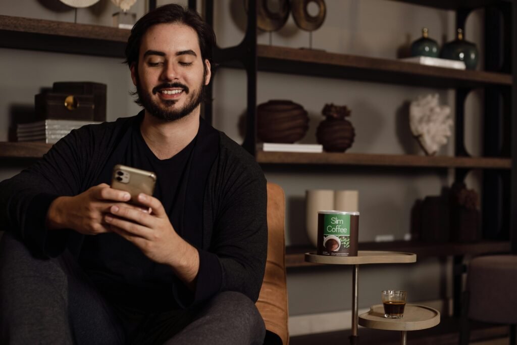 A cheerful young Pakistani man holding a smartphone showing a viral video about digital assets, representing how to sell digital products in pakistan.